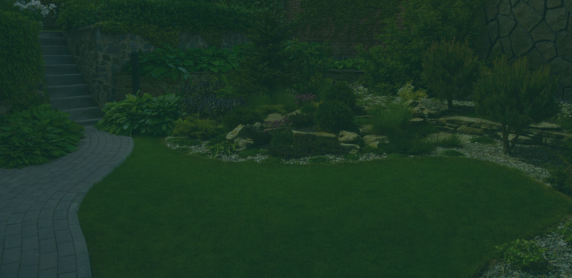 Gepflegter Garten mit Rasen, Steinbeeten und gepflastertem Weg – Gartenbau in Northeim